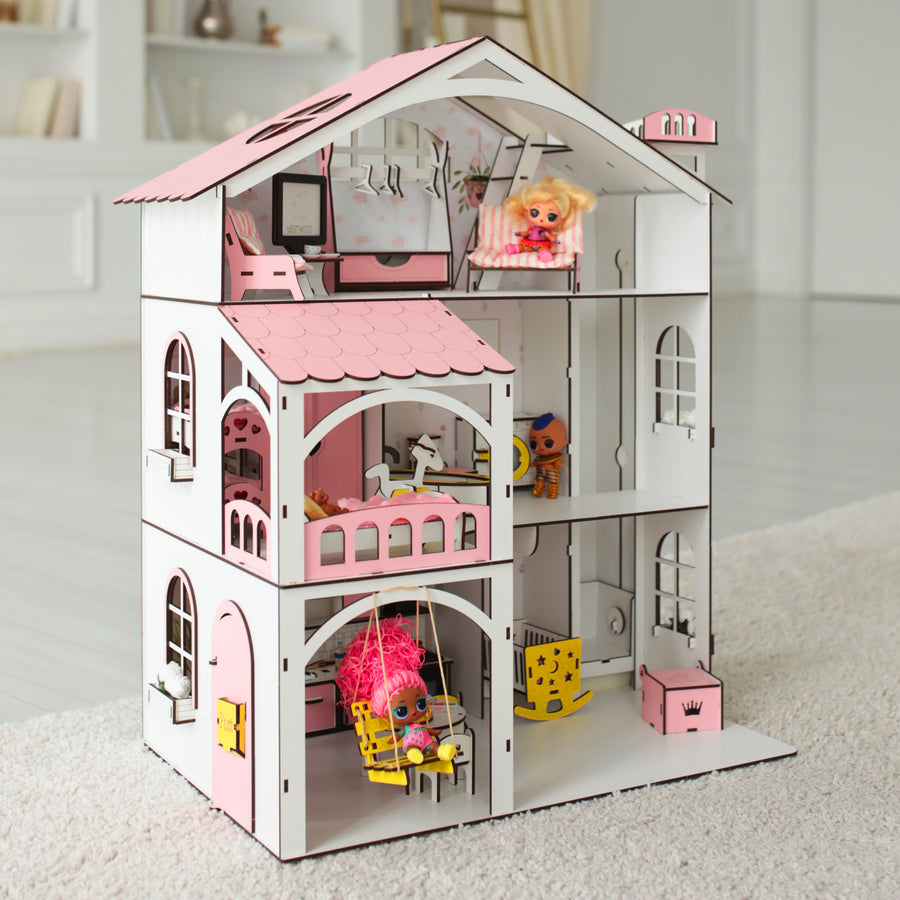 A pink and white wooden dollhouse with multiple floors and rooms, furniture, and decorative details.