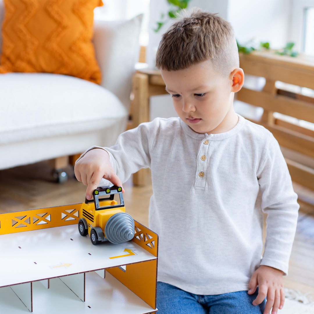 Child playing with a toy garage set in a room, featuring Nestwood branding.