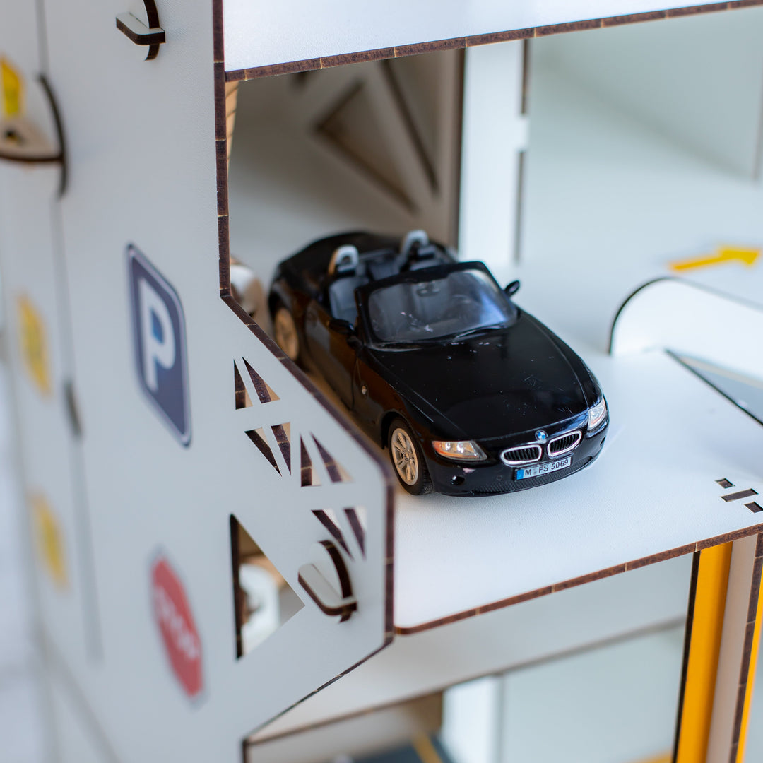 Child playing with a toy garage set in a room, featuring Nestwood branding.
