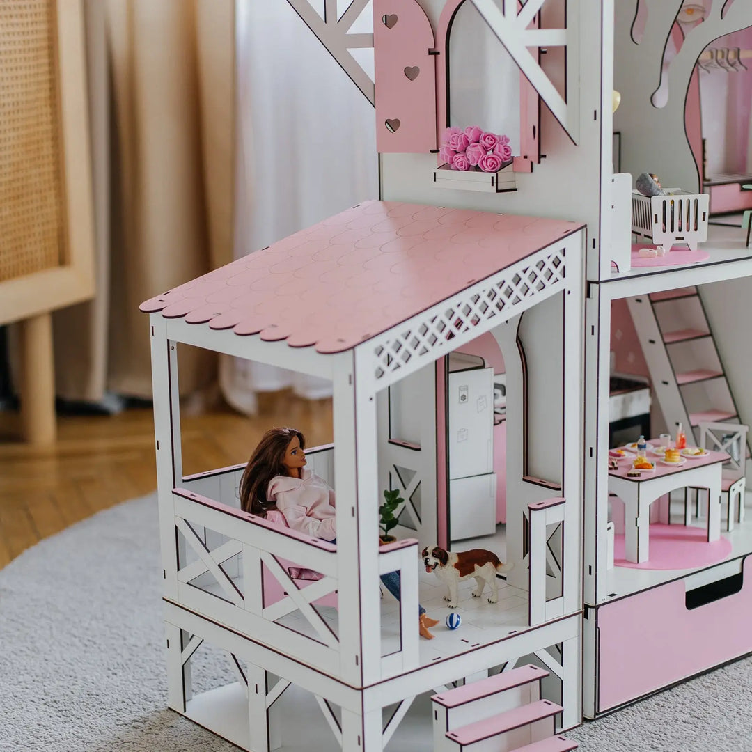 Dollhouse with a doll sitting on a chair inside, surrounded by furniture and decor.
