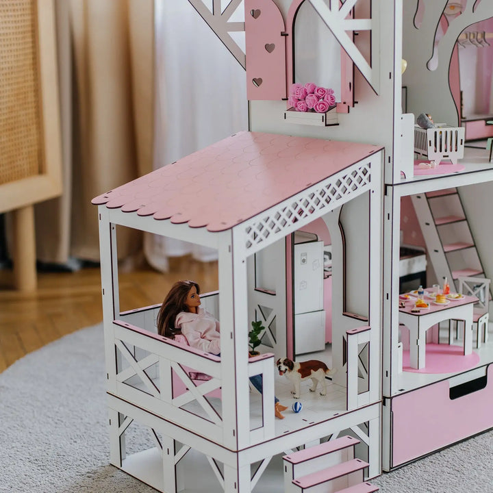 Dollhouse with a doll sitting on a chair inside, surrounded by furniture and decor.