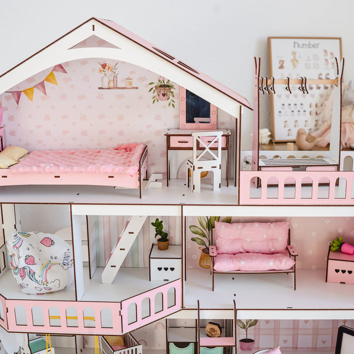Three-story dollhouse with pink interior and furniture in a room setting.