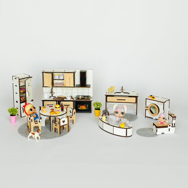 A miniature dollhouse-style kitchen and dining set with small figurines, tables, chairs, appliances, and decor, arranged on a plain light gray background.