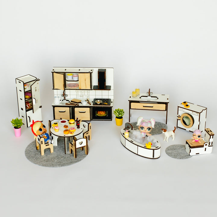 A miniature dollhouse kitchen and living room set with tiny furniture pieces, small plants, and tiny figurines on a light gray background.