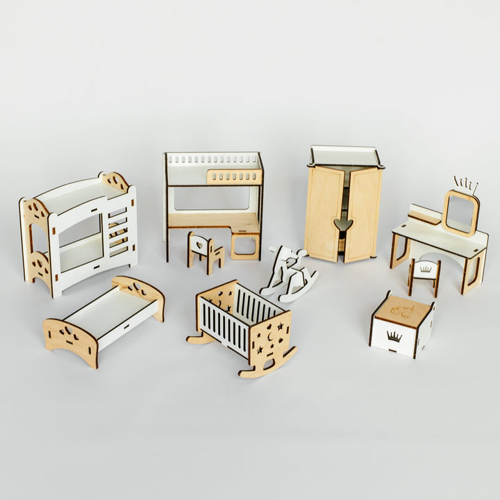 A miniature wooden dollhouse furniture set featuring a crib, changing table, dresser, rocking horse, and other baby accessories, arranged on a light gray background.