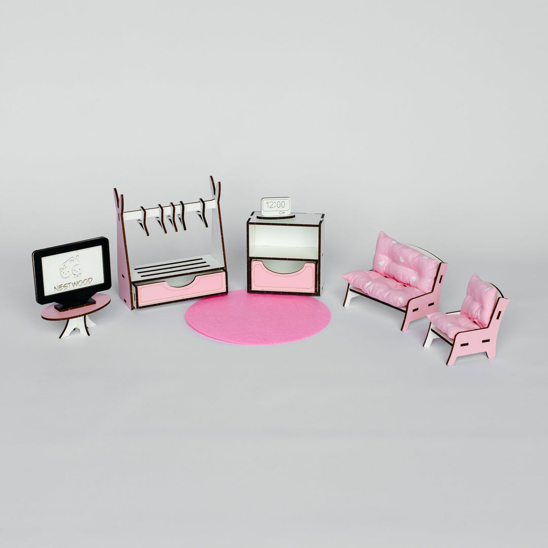 A miniature dollhouse furniture set in pink and white, including a desk with a computer monitor, a clothing rack, a cabinet, a round pink rug, a sofa, and two chairs, arranged on a light gray background.