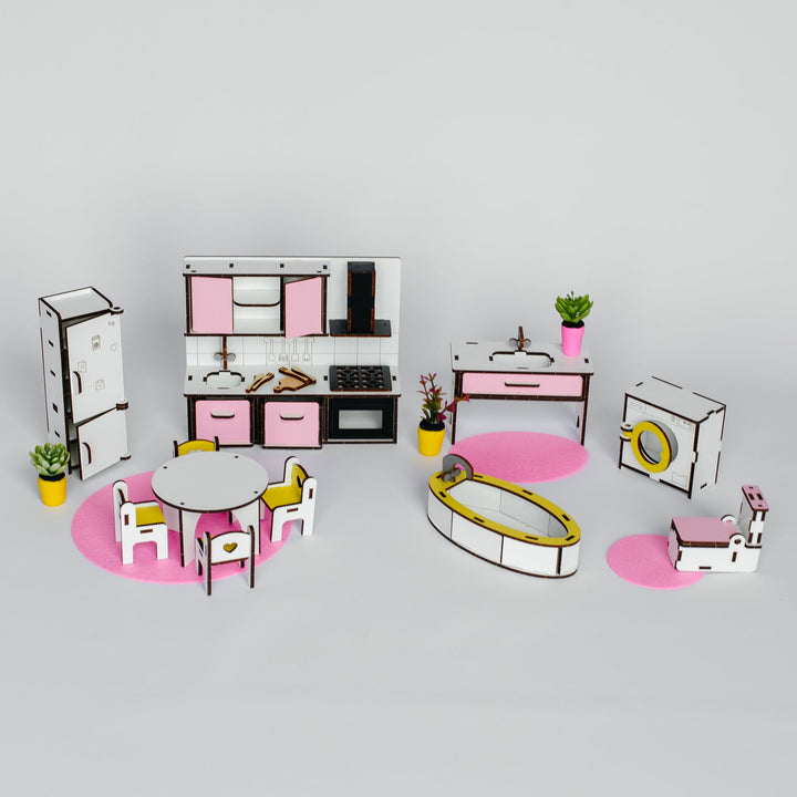 A miniature dollhouse kitchen and dining set with pink and white furniture, yellow chairs, and small potted plants, arranged on a light gray background.