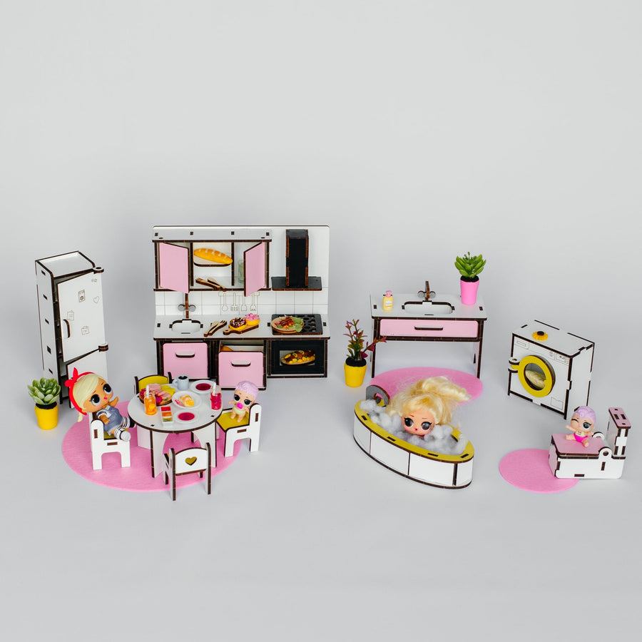A miniature dollhouse playset featuring a pink and white kitchen, dining room, bathroom, and bedroom with tiny furniture pieces, accessories, and small figurines, arranged on a light gray background.
