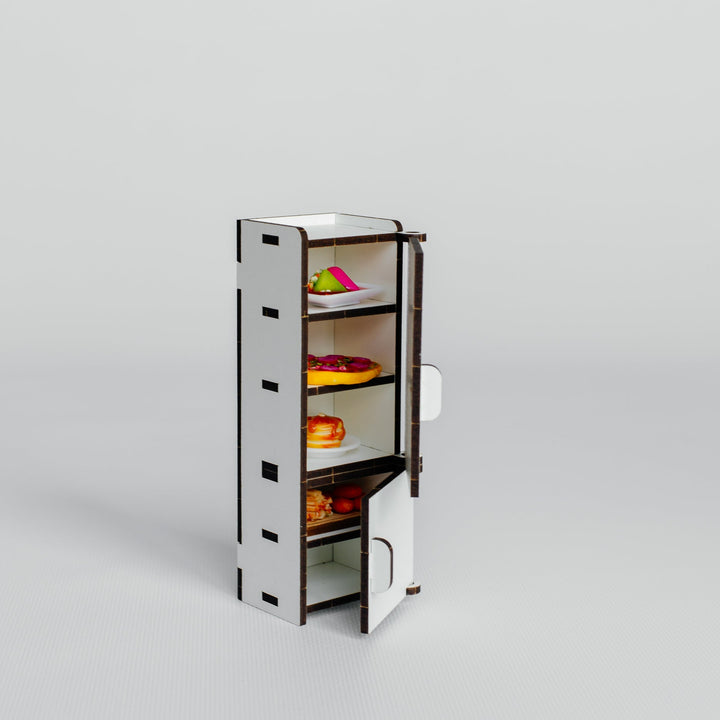 A miniature white and dark brown cardboard model of an open refrigerator, shown on a seamless light gray background.