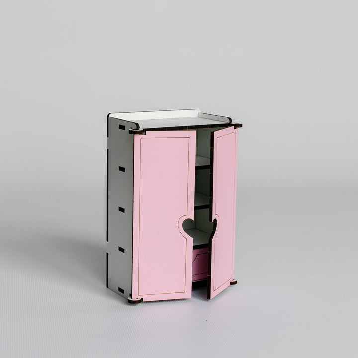 A small modern cabinet with two pink doors and a black frame, shown open on a light gray studio background.