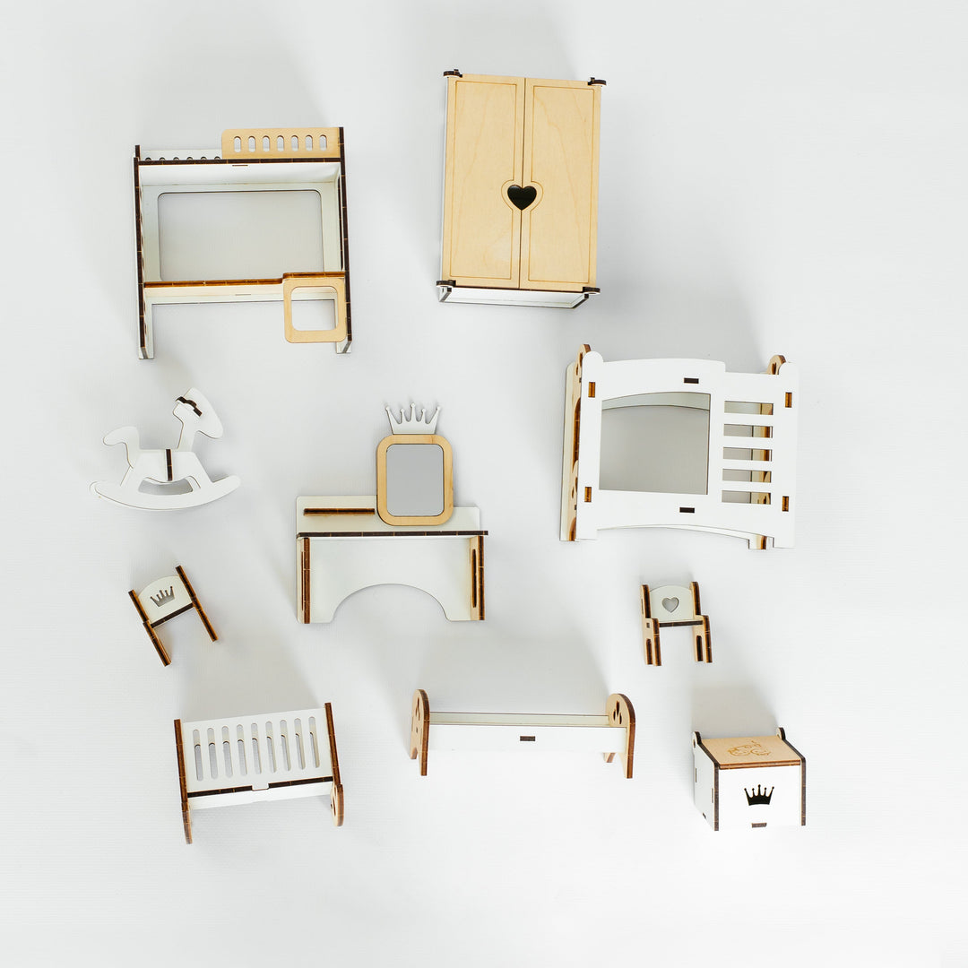 A collection of miniature dollhouse furniture pieces, including a wardrobe with a heart cutout, a bed, a desk, chairs, and other accessories, arranged on a seamless white background.