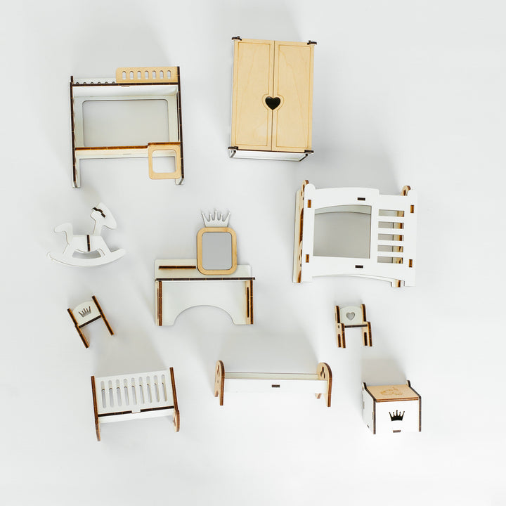 A collection of miniature dollhouse furniture pieces, including a wardrobe with a heart cutout, a bed, a desk, chairs, and other accessories, arranged on a seamless white background.
