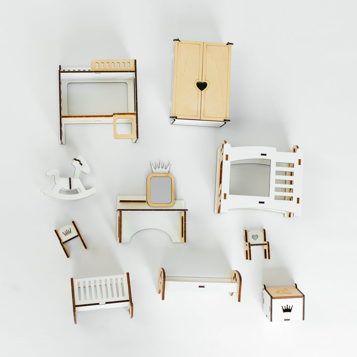 A collection of miniature dollhouse furniture pieces, including a wardrobe, bed, desk, chair, and shelves, arranged neatly on a seamless white background.