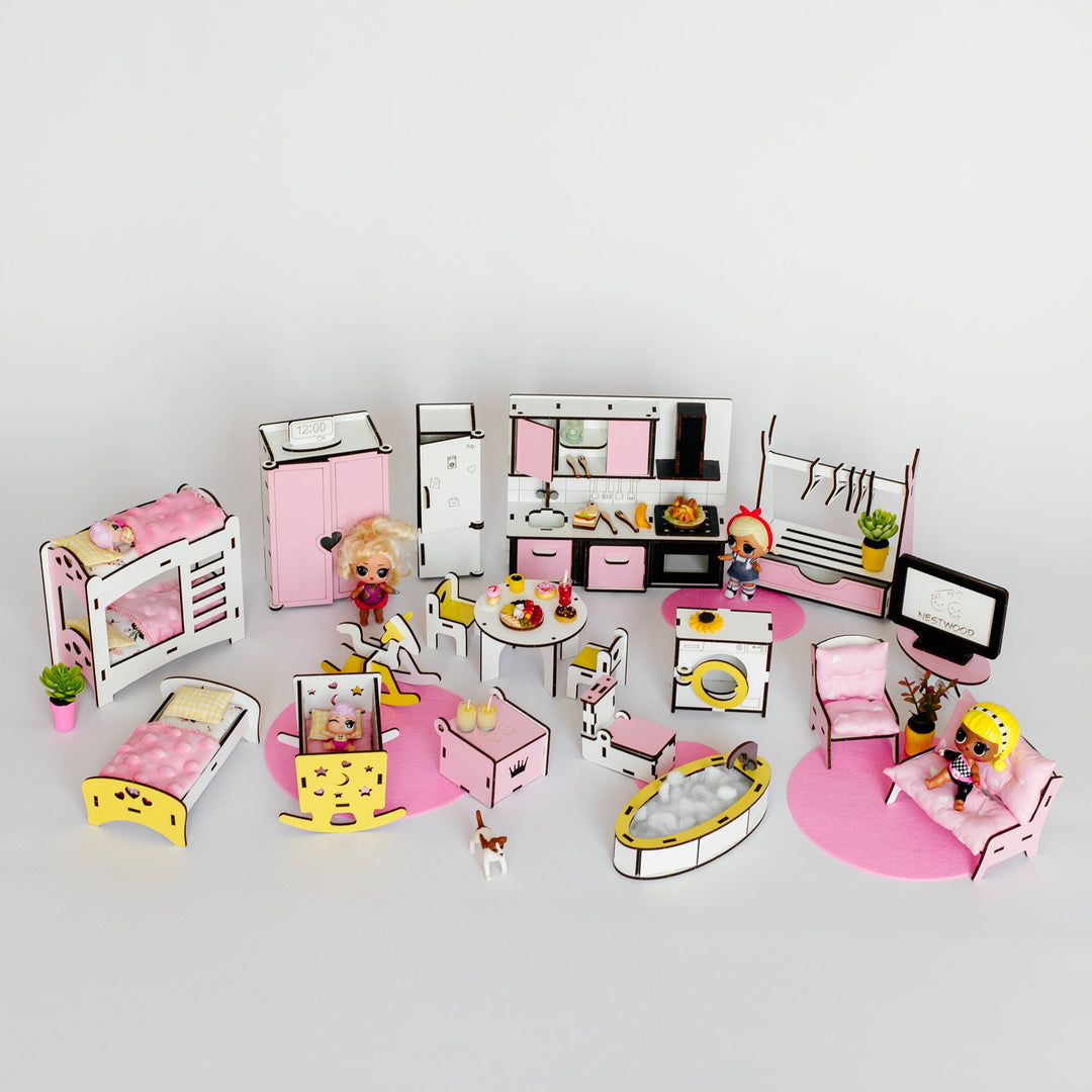 A miniature dollhouse bedroom set with pink and white furniture, including a bed, bunk bed, kitchen, dining table, computer, and small character figures, arranged on a light gray background.