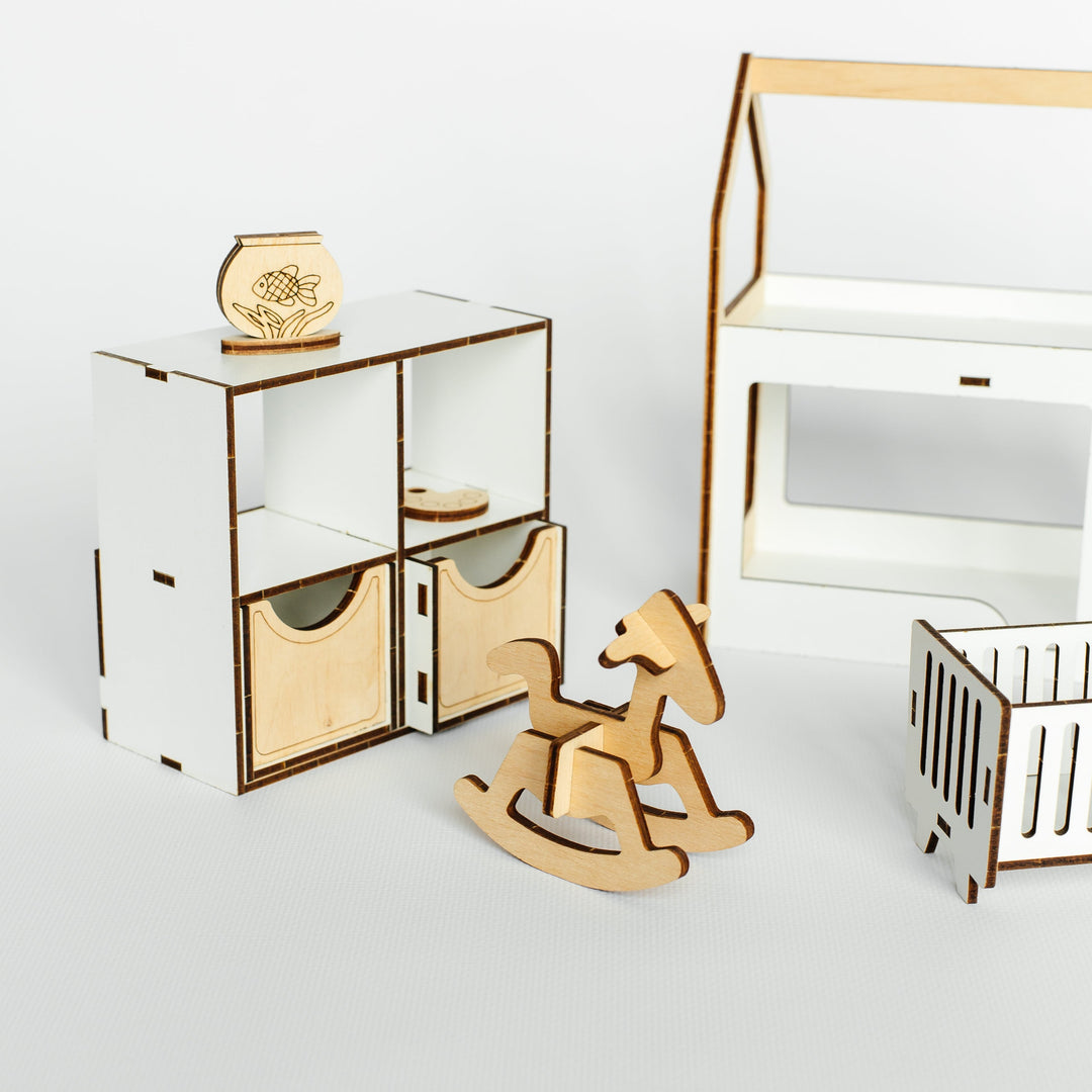 A set of laser-cut wooden baby toys and furniture pieces, including a small storage organizer, a rocking horse, a dollhouse-style house, and a crib, arranged on a light gray studio background.
