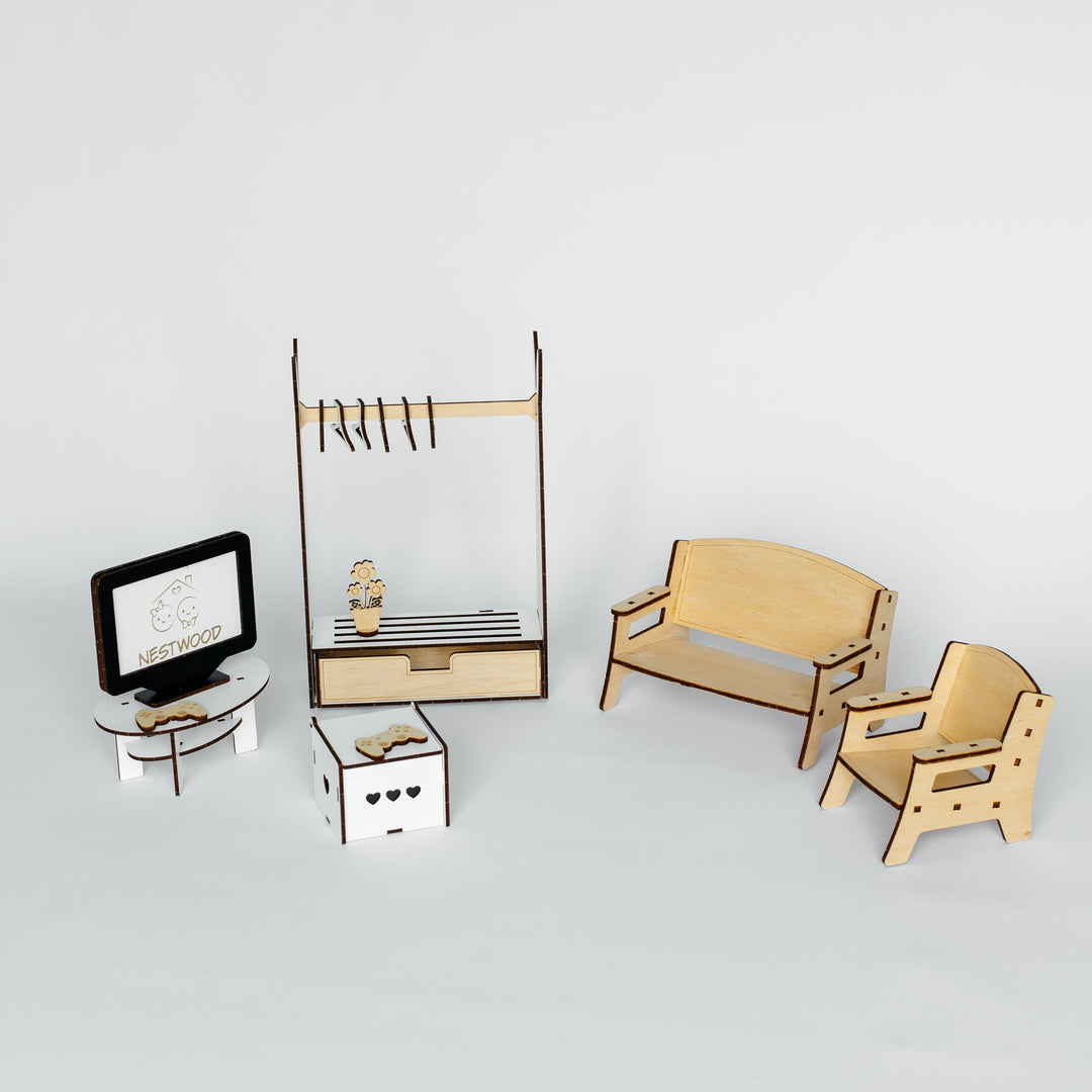 A miniature dollhouse furniture set made of laser-cut light wood and white materials, including a sofa, armchair, cabinet, clothing rack, and small desk accessories, displayed on a light gray background.