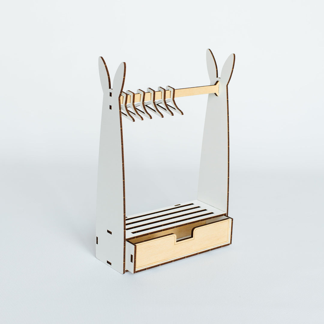 A minimalist wooden coat rack with a slatted base and a small drawer, shown on a clean light gray background.