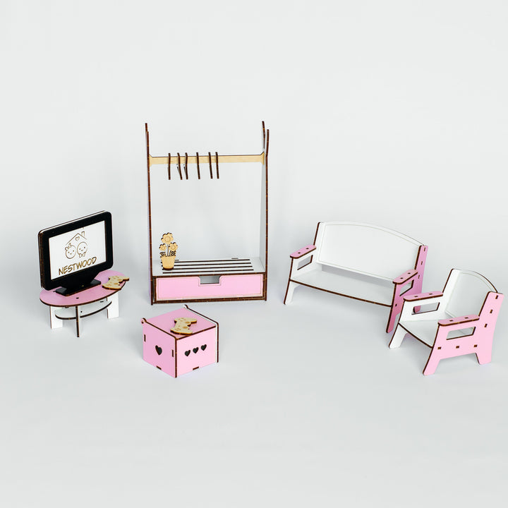 A miniature dollhouse furniture set featuring a pink and white sofa, matching armchair, a clothing rack, a small desk with a TV, and a storage box, arranged on a light gray background.