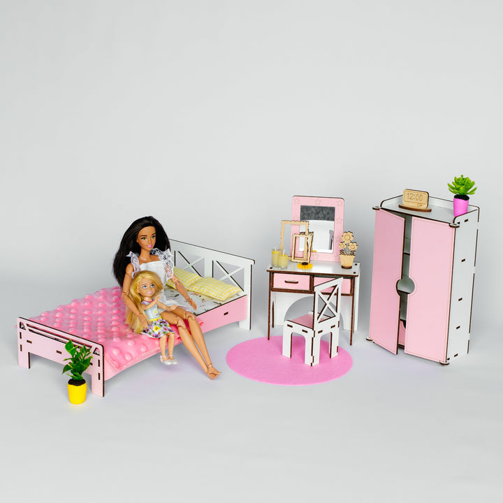 A dollhouse-style bedroom set with a bed, desk, chair, wardrobe, and accessories, shown with two dolls on a light gray studio background.