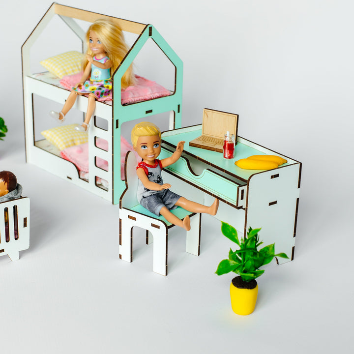 A miniature dollhouse-style children's bedroom set with a bunk bed, desk, chair, and small accessories, shown with two dolls on a clean white background.