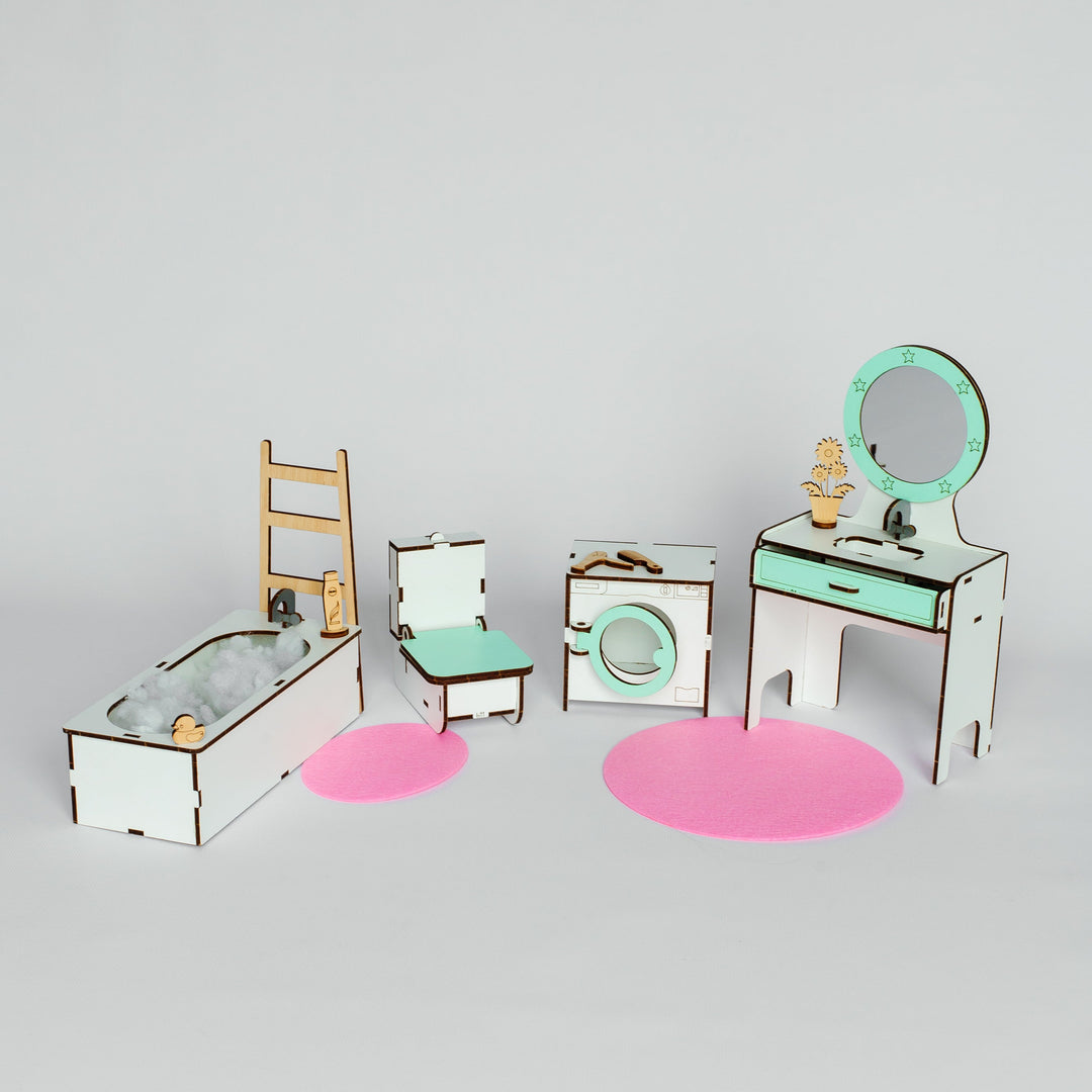 A miniature dollhouse-style bathroom furniture set with a bathtub, ladder, chair, washing machine, vanity table, mirror, and pink circular rugs on a light gray background.