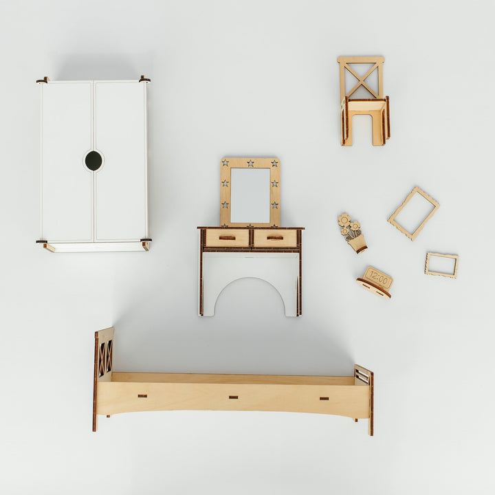 A minimalist furniture set arranged on a clean white background, including a white cabinet, a light wood bed frame, a matching desk with drawers and mirror, a chair, and small decor pieces.