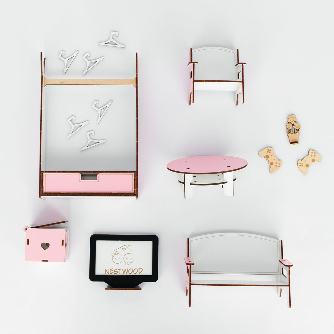 A top-down view of a miniature dollhouse furniture set on a white background, including a bed with pink bedding, a chair, a round pink coffee table, a bench, a small cabinet, and a TV stand.