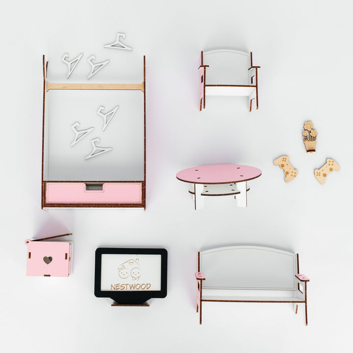 A top-down view of a miniature dollhouse furniture set on a white background, including a bed with pink bedding, a chair, a round pink coffee table, a bench, a small cabinet, and a TV stand.