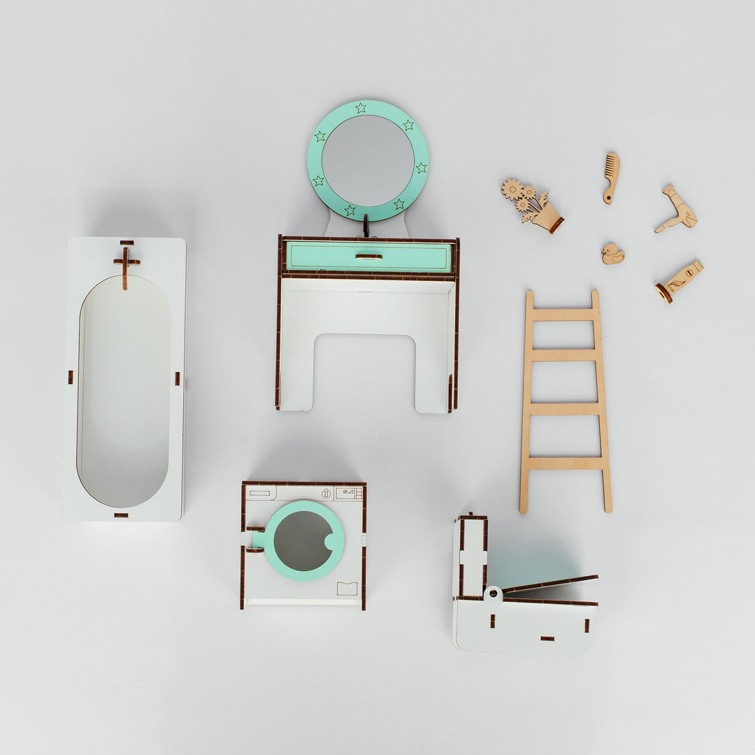 A set of miniature wooden toy furniture and bathroom accessories, including a bathtub, vanity table, mirror, stool, ladder, and small wooden figurines, arranged on a light gray background.