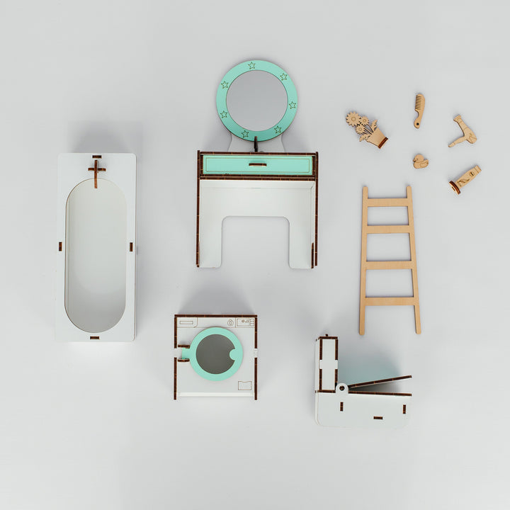 A miniature toy furniture set arranged on a light gray background, featuring a white bathtub, a vanity table with a mint green drawer and round mirror, a wooden ladder, small wooden figurines, and other matching accessories.