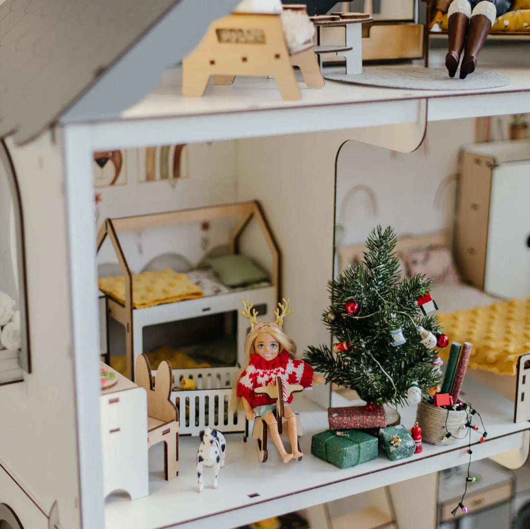 Miniature dollhouse with Christmas decorations and a tree.