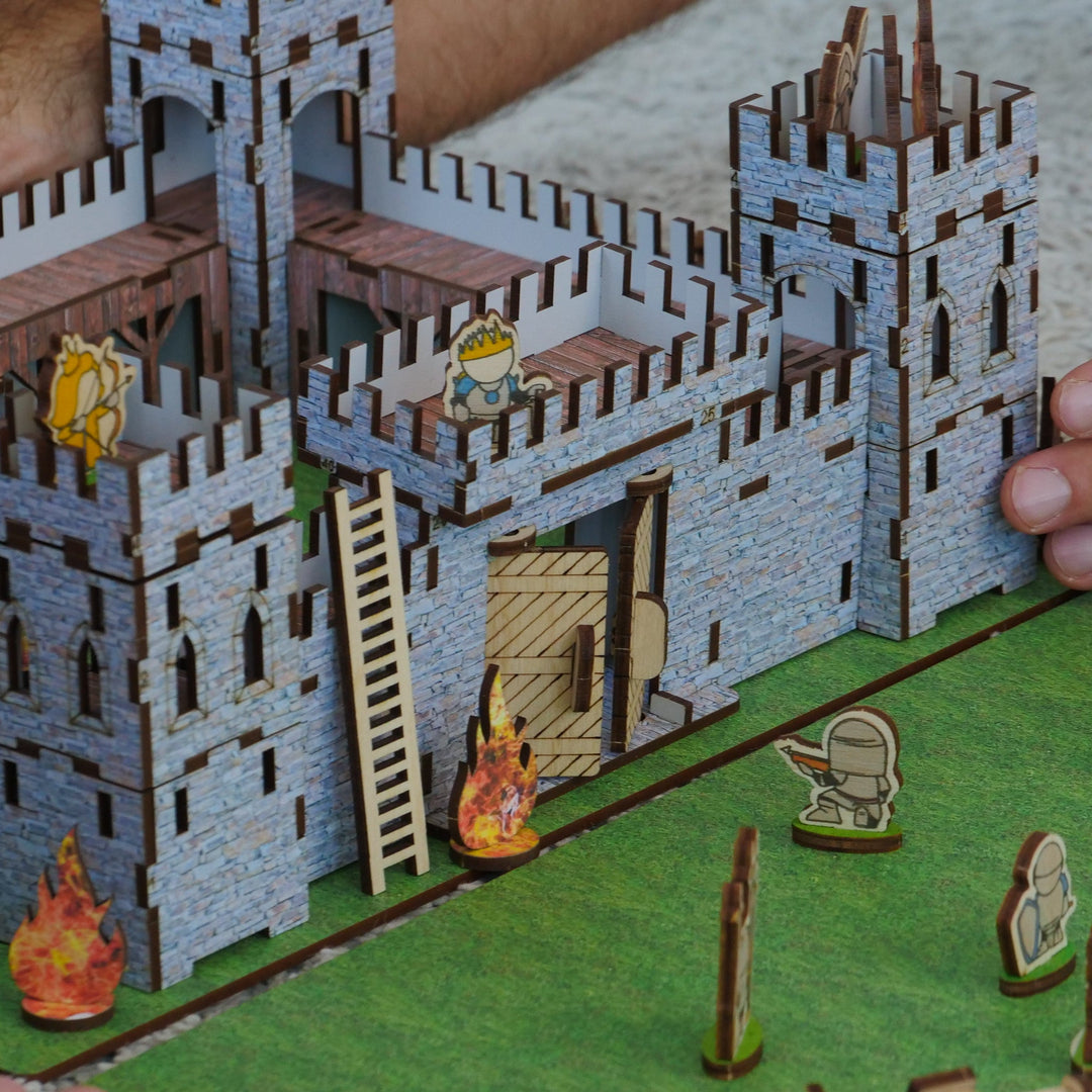 Model of a castle with small figures on a green base