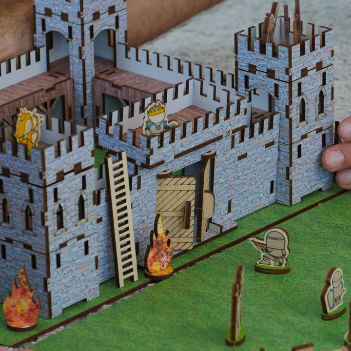 Model of a castle with small figures on a green base