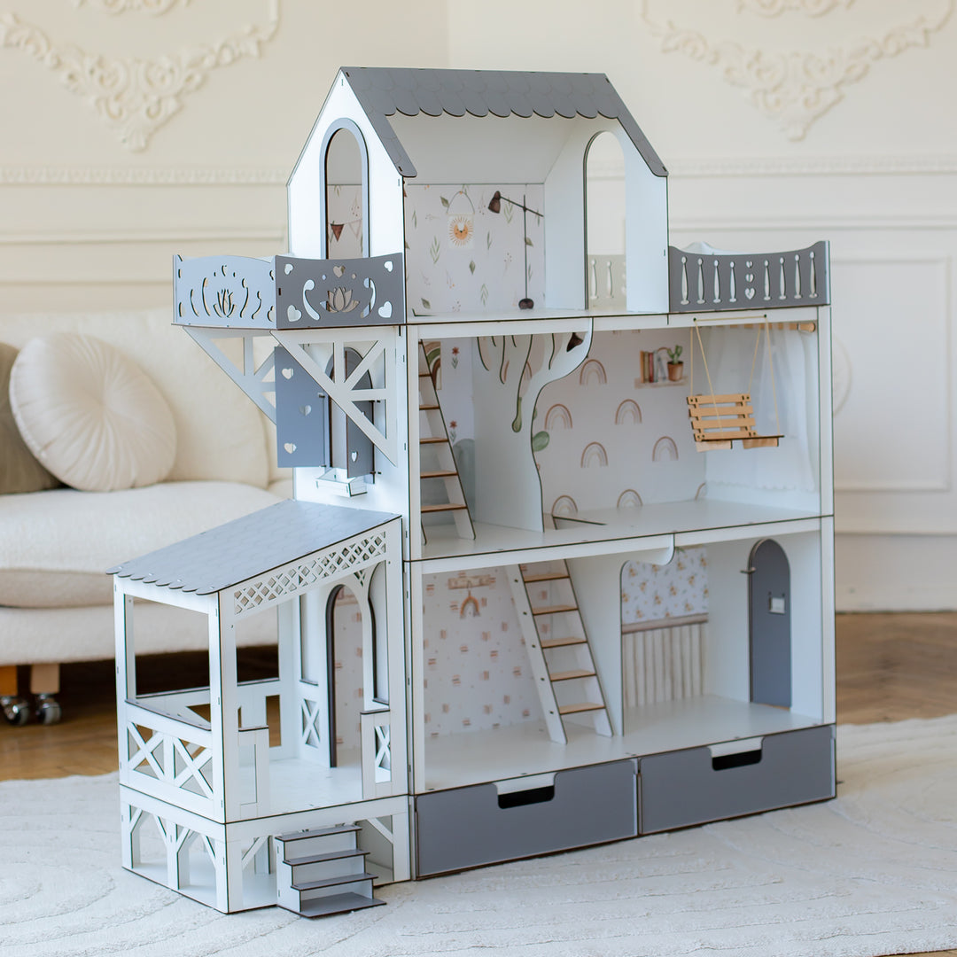 A child playing with a big gray wooden dollhouse with balcony and terrace. The dollhouse is multistory and has furniture inside.