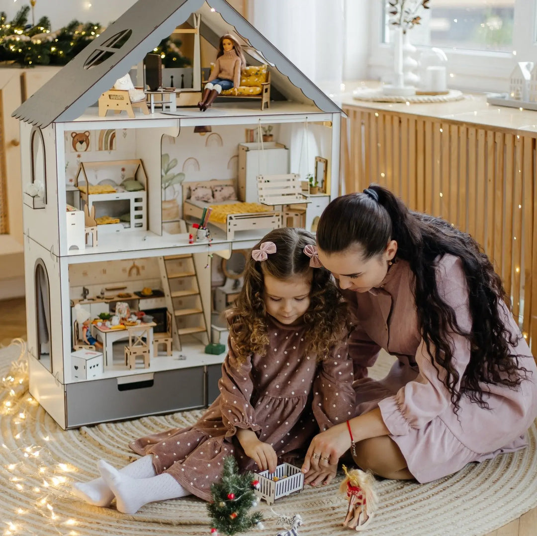 Woman and child playing with a dollhouse in a cozy room.
