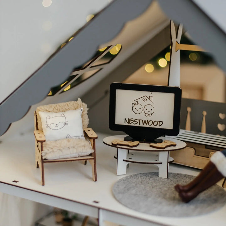 Miniature room setup with a chair, table, and 'NESTWOOD' sign on a blurred background.
